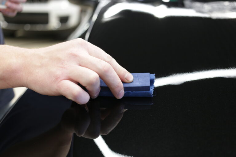 car-service-worker-applying-nano-coating-car-detail-closeup-hand-coating-black-car-paint